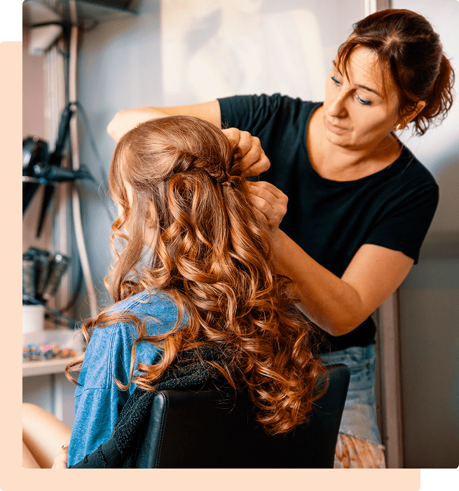 Hair stylist braiding woman's hair