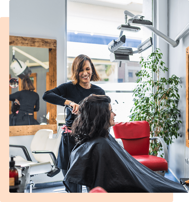 Hairdresser styling woman's hair in salon