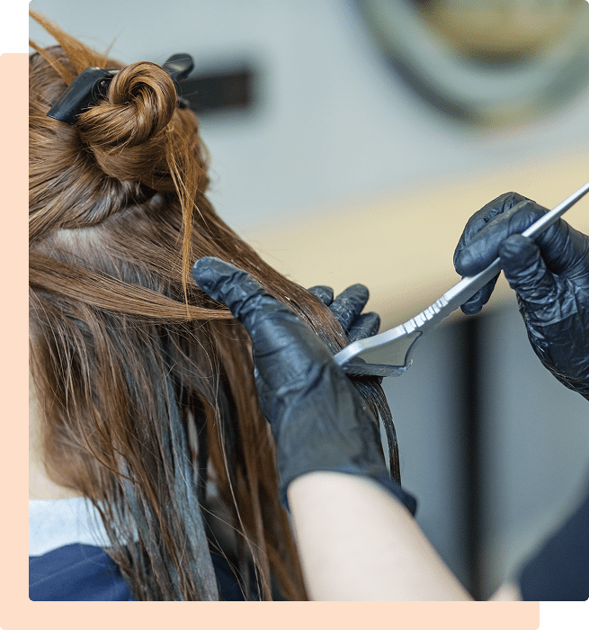 A hairstylist cutting a client's hair with scissors.