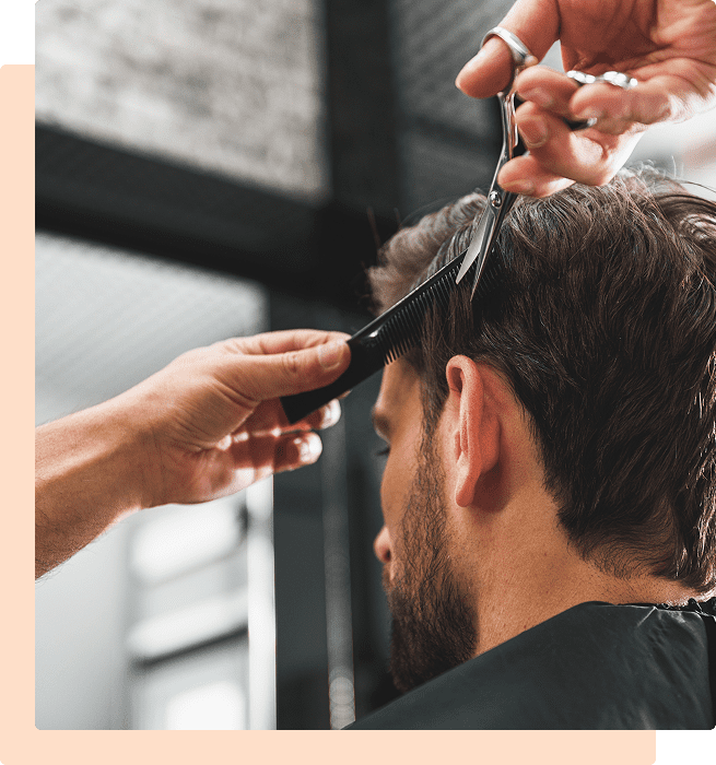 A man getting a haircut at a barbershop.