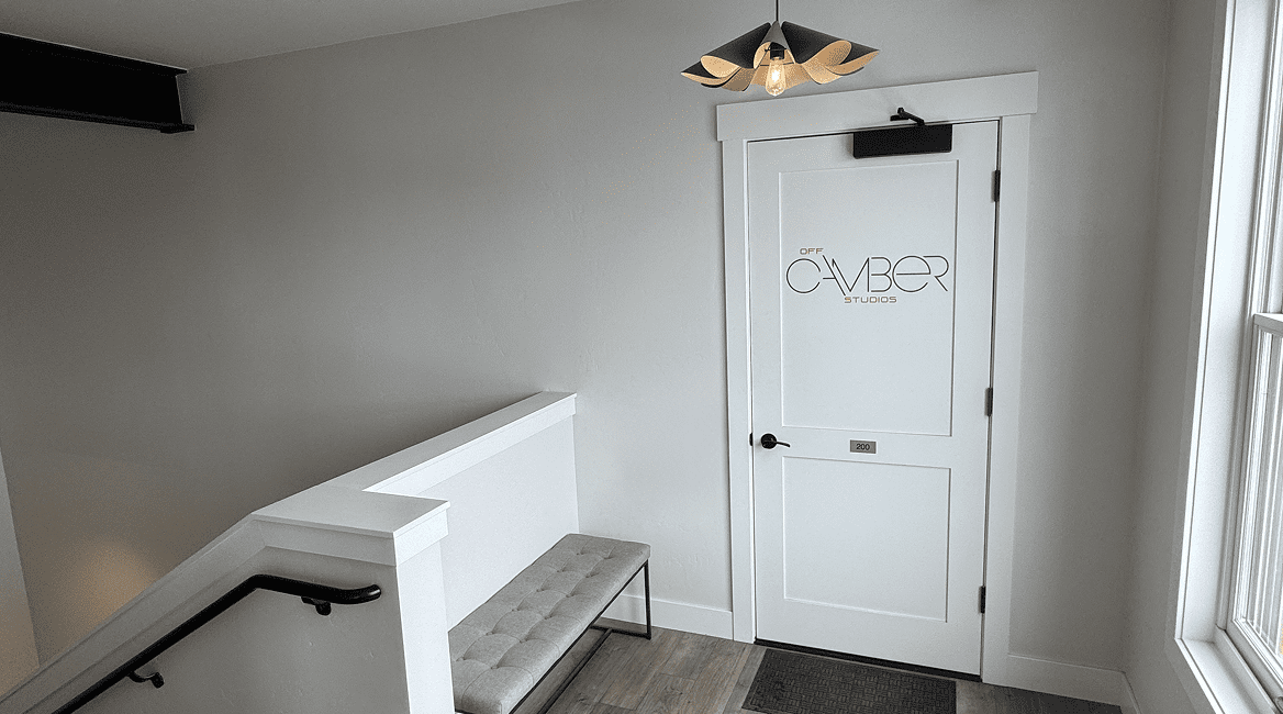 Minimal stair landing with white door and bench
